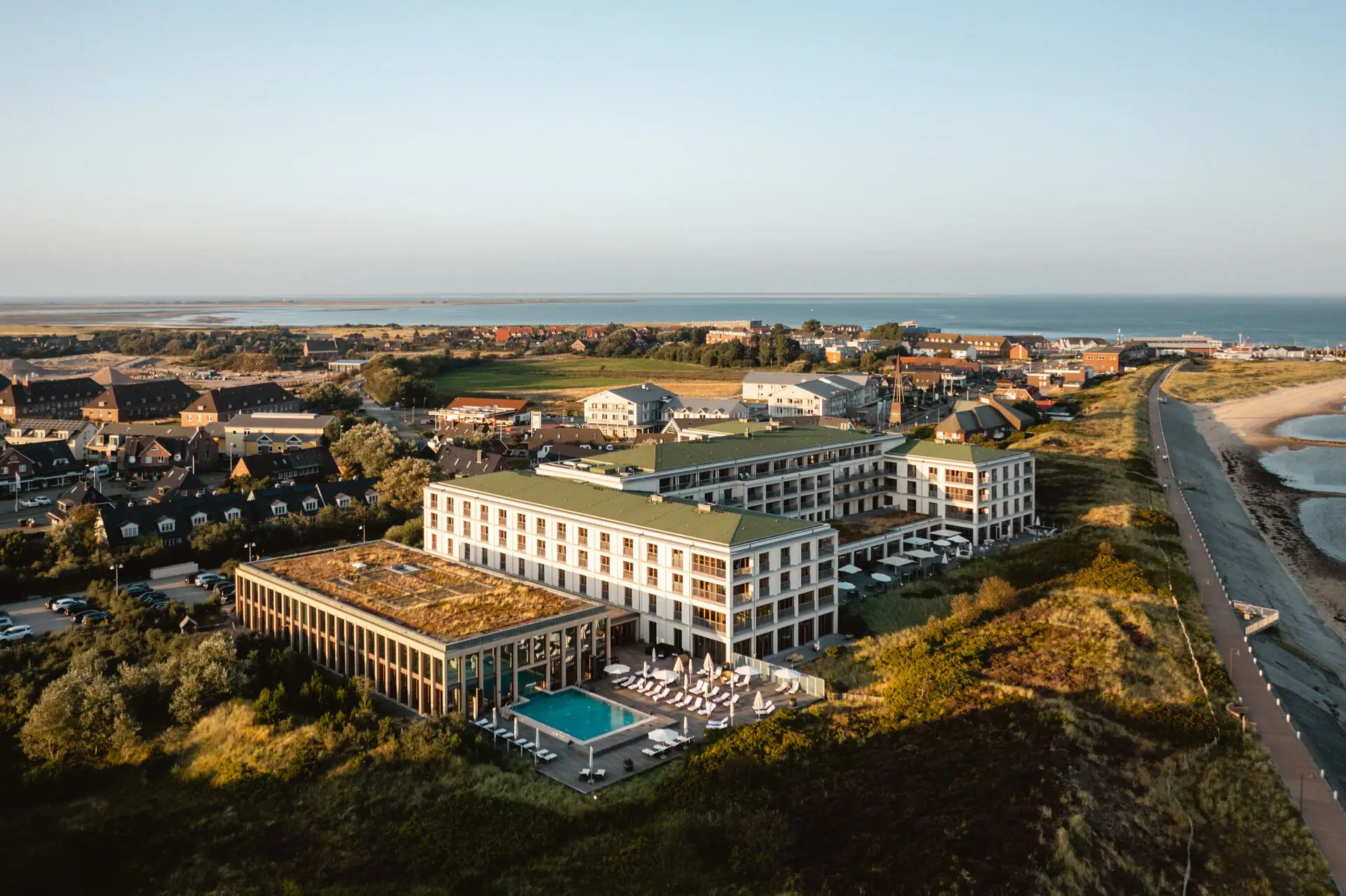 A-ROSA Sylt Das A-ROSA Sylt mit Pool direkt an den Dünen gelegen mit dem Strand und der Nordsee daneben.