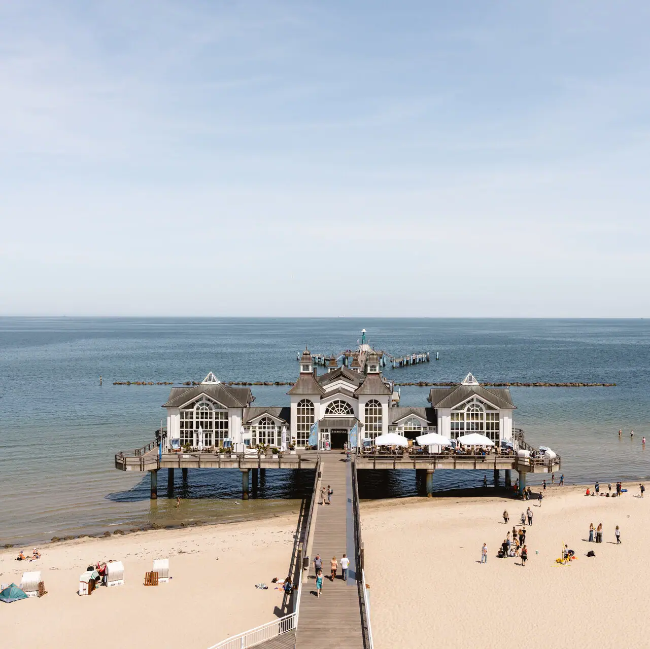 Strand mit einem Gebäude auf dem Wasser.