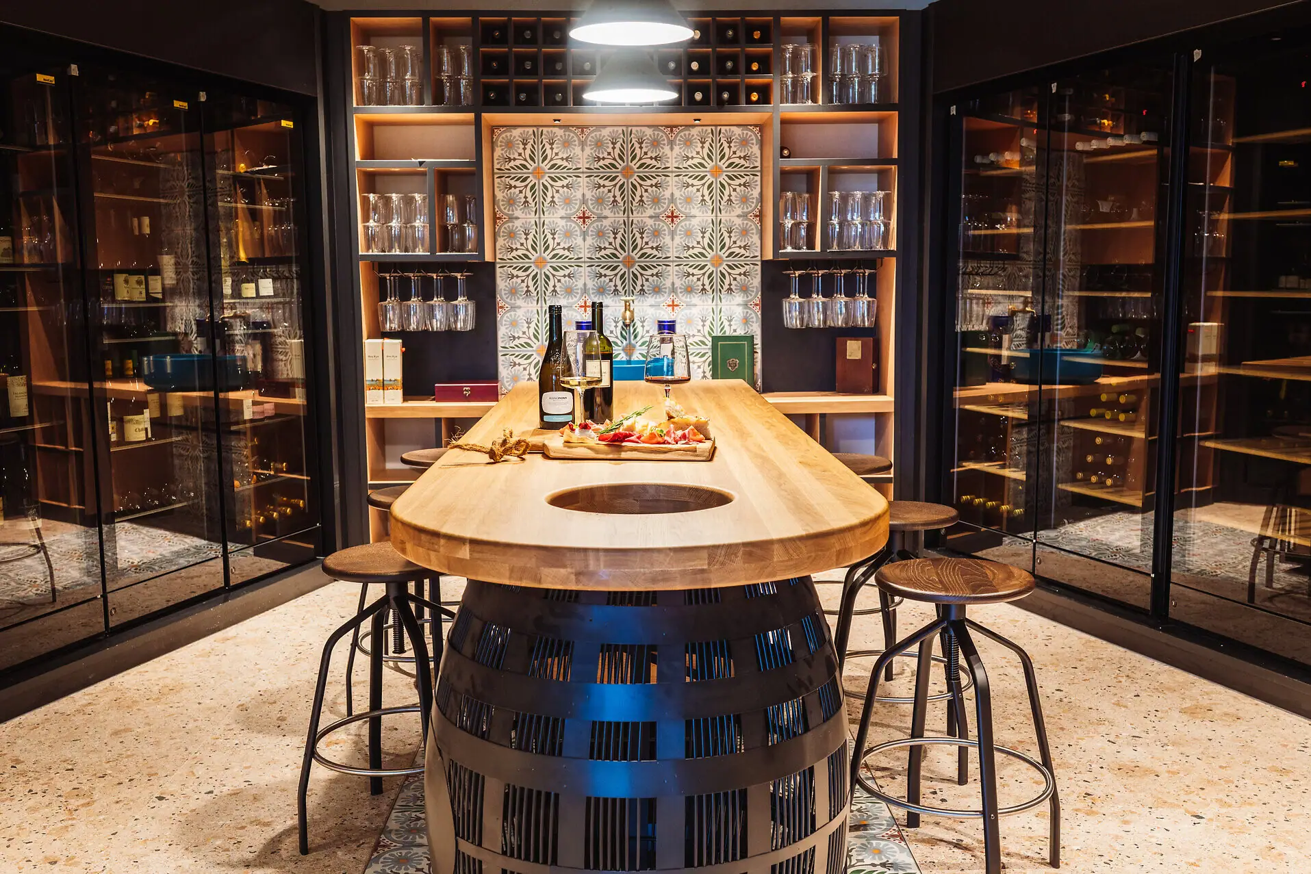 Enoteca im A-ROSA Gardasee Ein Tisch mit Weinflaschen und kleinen Snacks darauf.