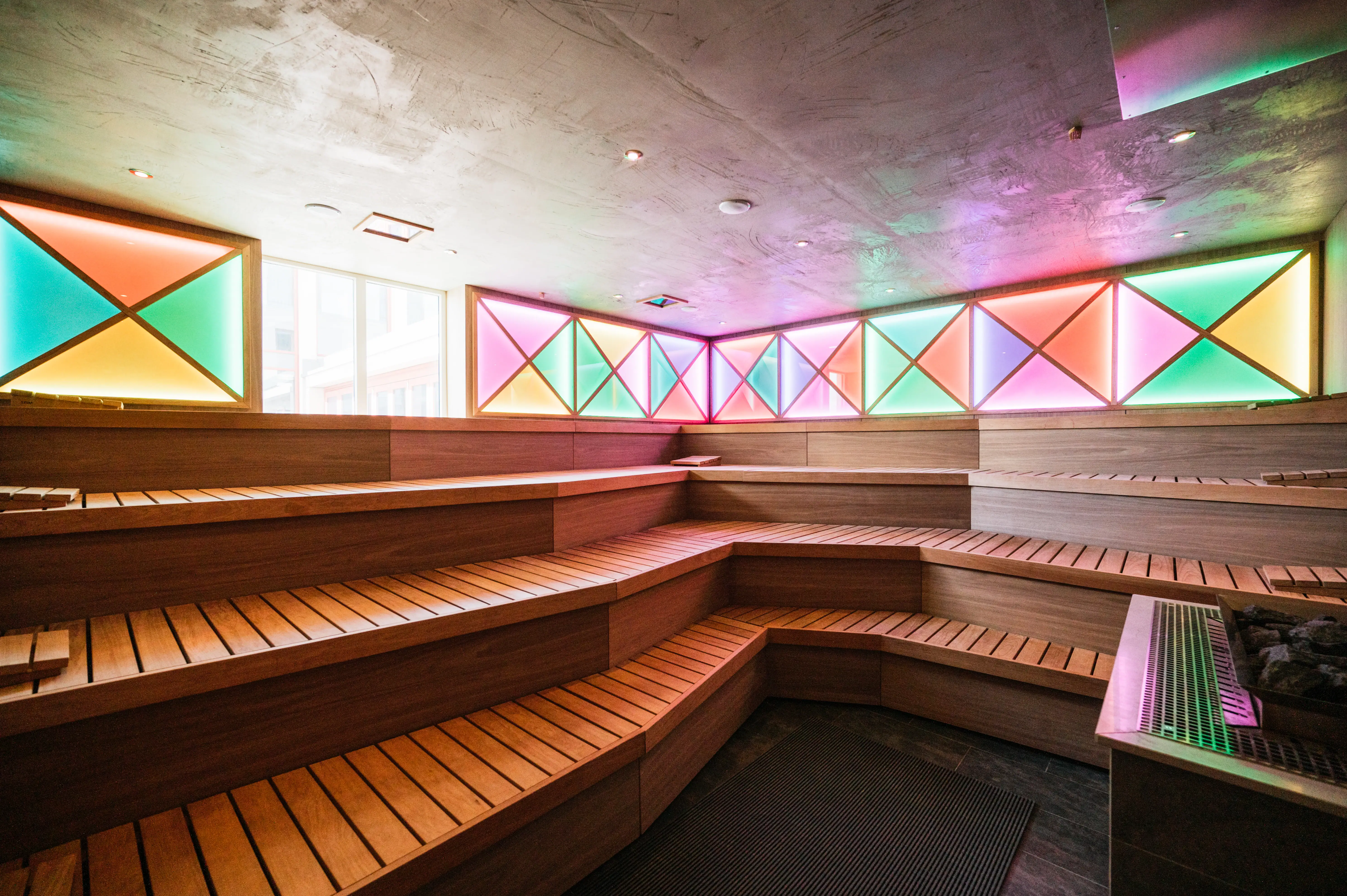 Eventsauna auf Sylt Eventsauna mit bunten Lichtern und Sitzbänken aus Holz.