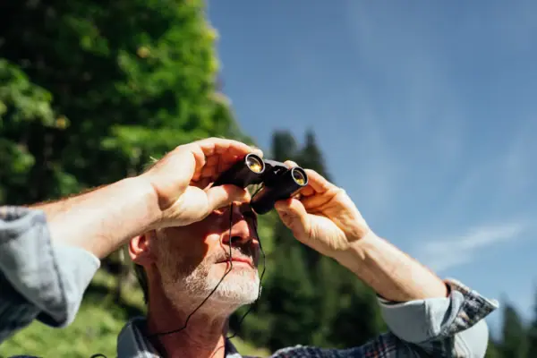 Mann schaut ins Fernglas Ein Mann schaut durch ein Fernglas.