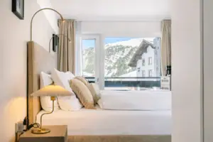 Zimmer Ein Bett mit Kissen und einer Lampe vor einem Fenster.