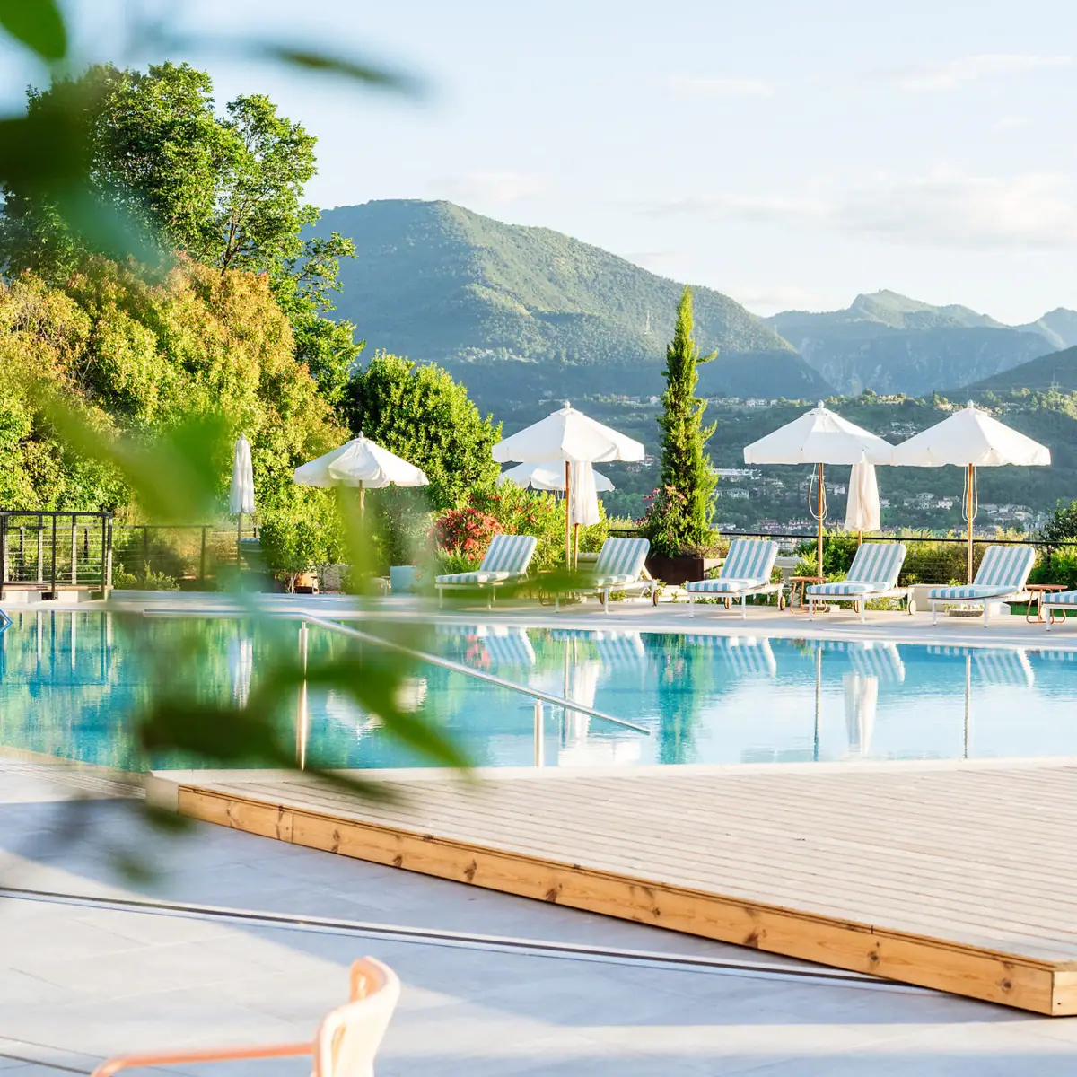 Ein Außenpool mit Liegestühlen und Sonnenschirmen.
