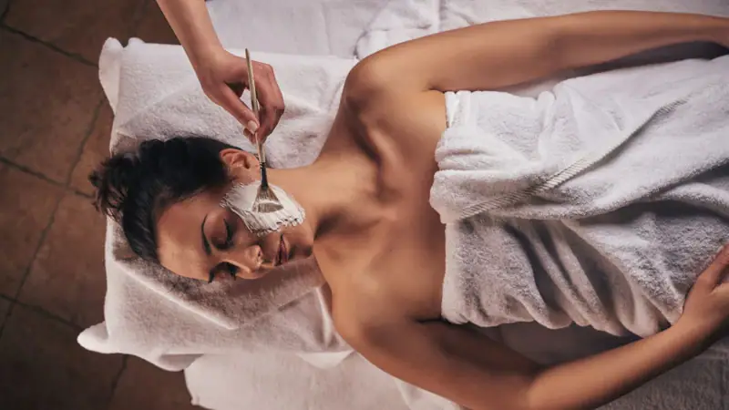 Eine Frau liegt mit einer Maske auf dem Gesicht.