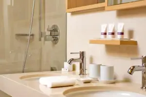 Waschbecken mit Wasserhahn und Dusche im Badezimmer