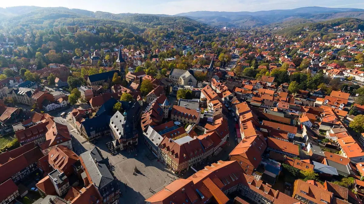Drohnenaufnahme Wernigerode Luftaufnahme einer Stadt mit Häusern, Bäumen und Himmel im Hintergrund.