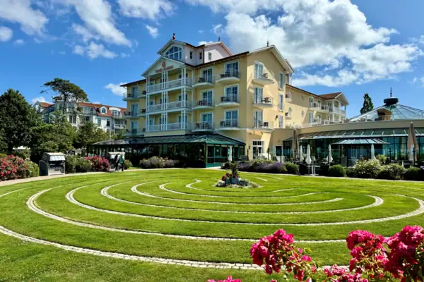 Runder Rasen mit Blumen vor einem Gebäude.