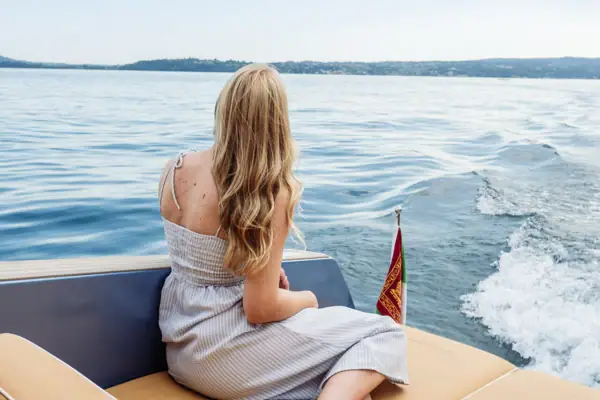 Bootstour Gardasee Eine Frau sitzt auf einem Boot.