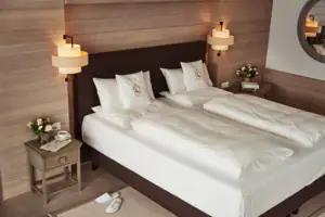 Zimmer Ein Bett mit weißen Laken und Kissen.