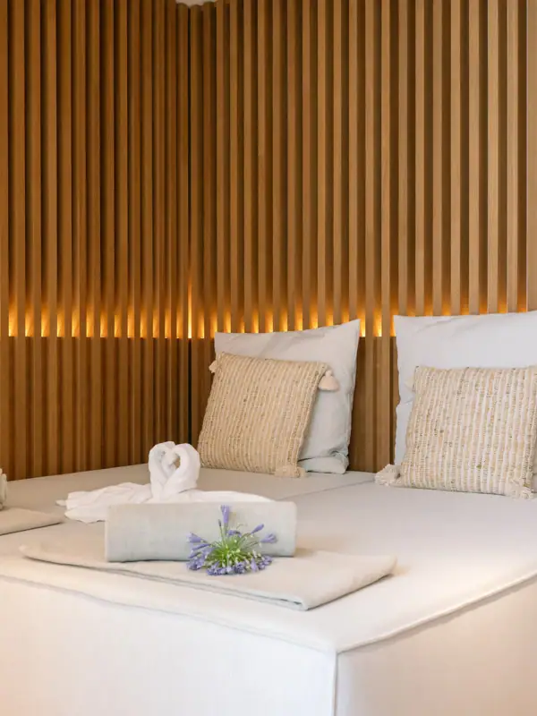 Ein Bett mit Kissen und Handtüchern darauf.