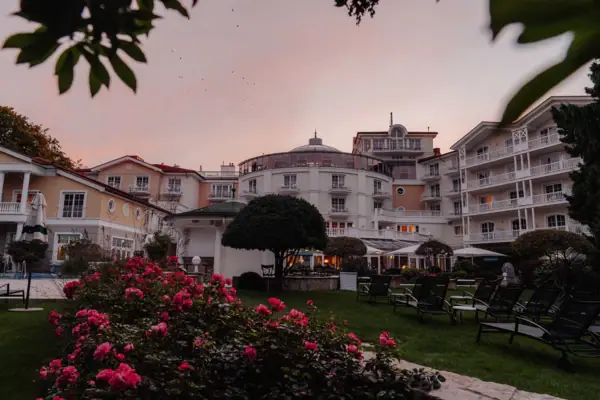 A-ROSA Heringsdorf Außengarten Rasen mit Stühlen und Blumen vor einem Gebäude