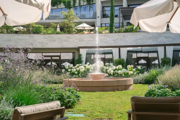 Terrasse mit Stühlen und Sonnenschirmen vor einem Gebäude