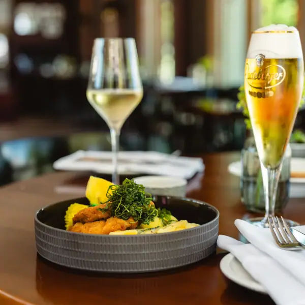 Tellerwerk Travemünde Ein Teller mit Essen und ein Glas Wein.