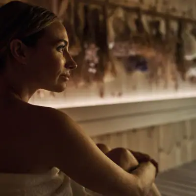 Eine Frau sitzt in einer Sauna.