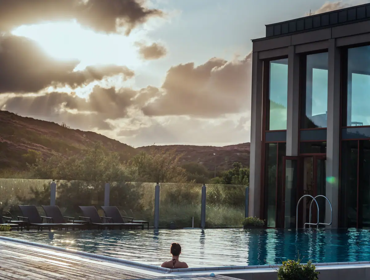Eine Frau in einem Pool mit einem Gebäude im Hintergrund.