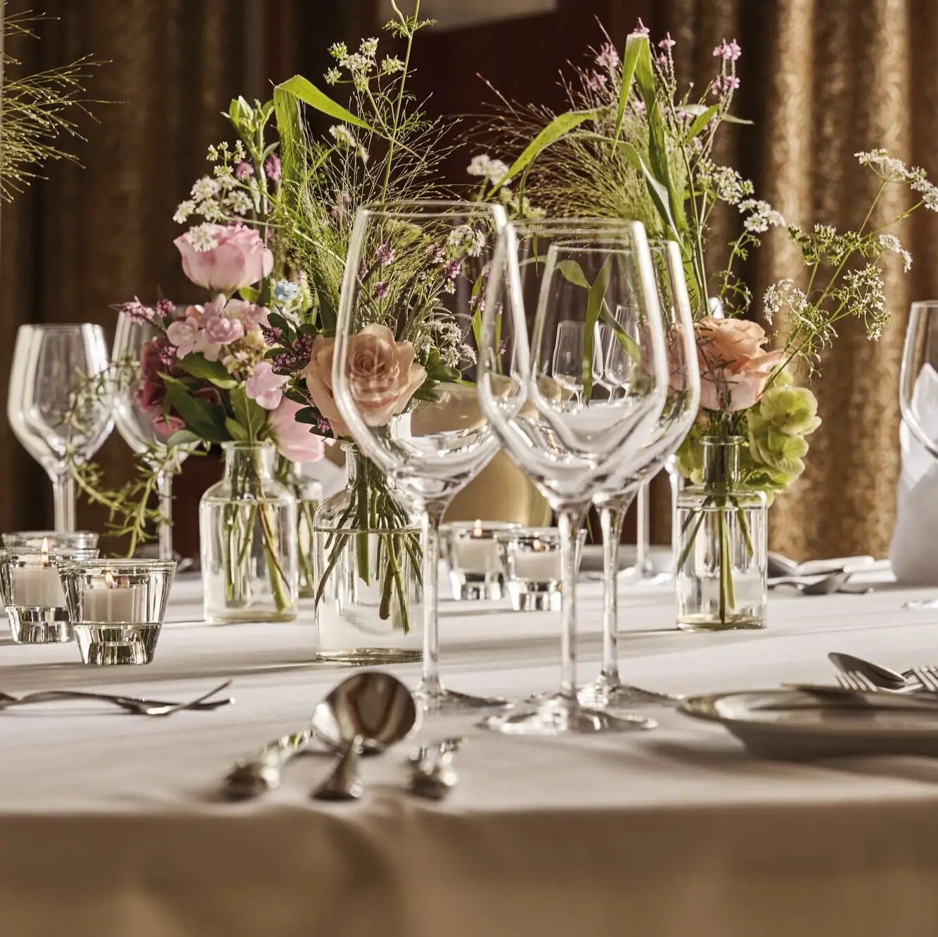 Ein Tisch mit Blumenarrangement und Kerzen.