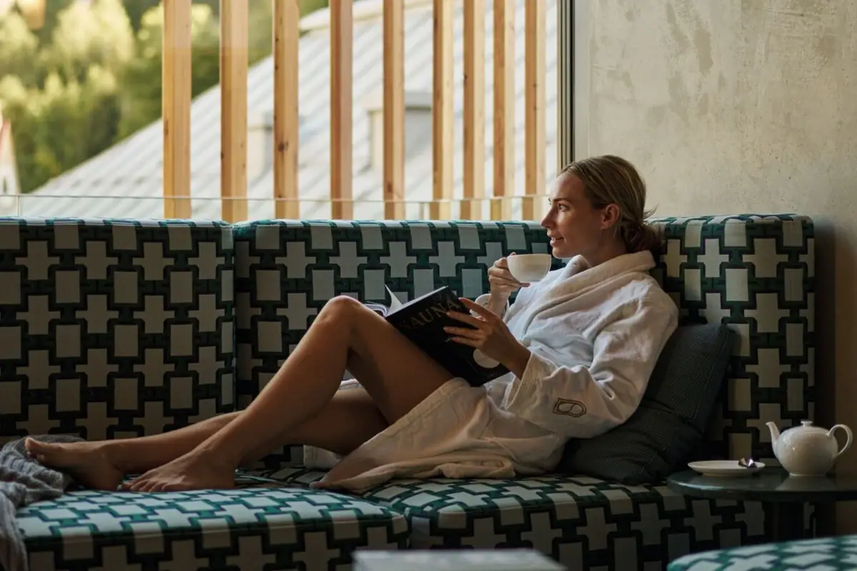 Eine Runde Me Time Eine Frau trinkt Tee im Bademantel und schaut nach draußen