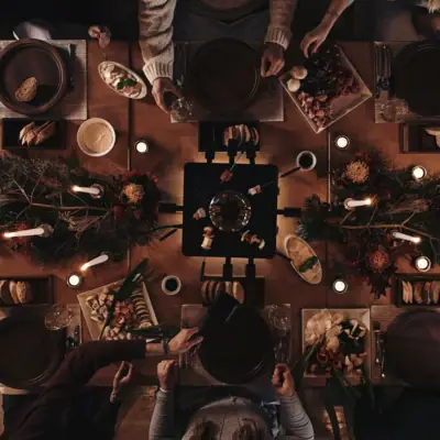 Eine Gruppe von Menschen sitzt um einen Tisch mit Essen.