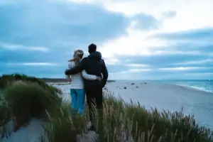 Dünen Ein Mann und eine Frau stehen am Strand.