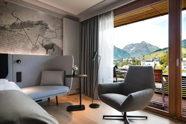 Zimmer Ein modernes Hotelzimmer mit einem Sofa, einem Tisch und einem Stuhl.