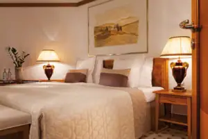 Zimmer Ein Bett mit Lampen und einem Gemälde an der Wand.