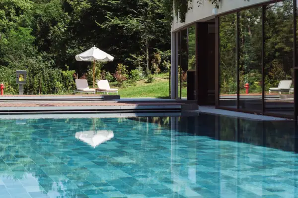 Sprudelpool im A-ROSA Gardasee Ein Außenpool mit Pflanzen an der Seite eines Gebäudes.