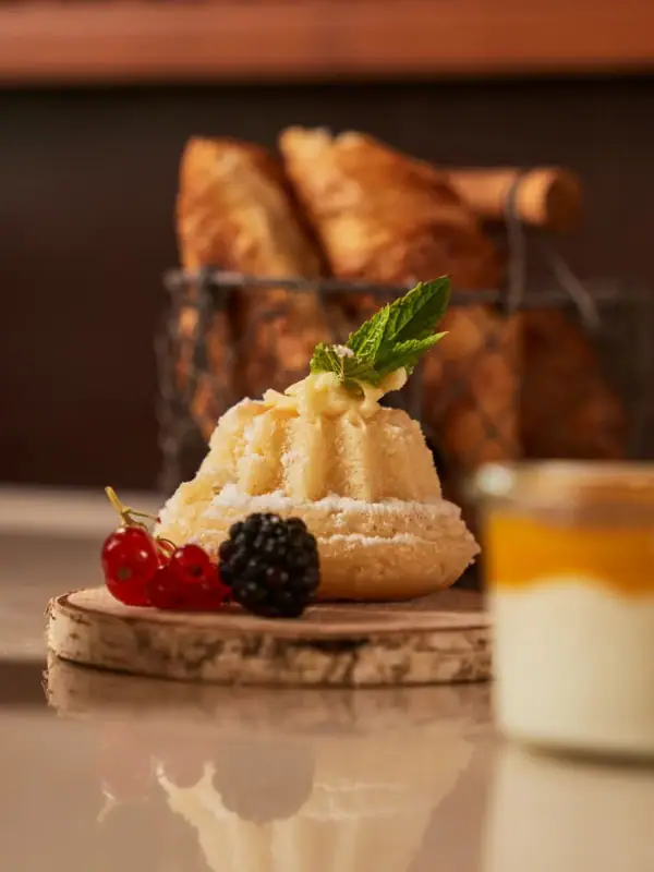 Ein Dessert auf einem Tisch mit kunstvoll angerichteten Früchten und einer Erdbeergarnitur.