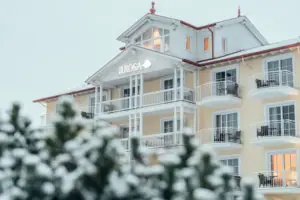 A-ROSA Ostseehotel Kühlungsborn Ein Gebäude mit Schnee auf dem Boden im Winter.