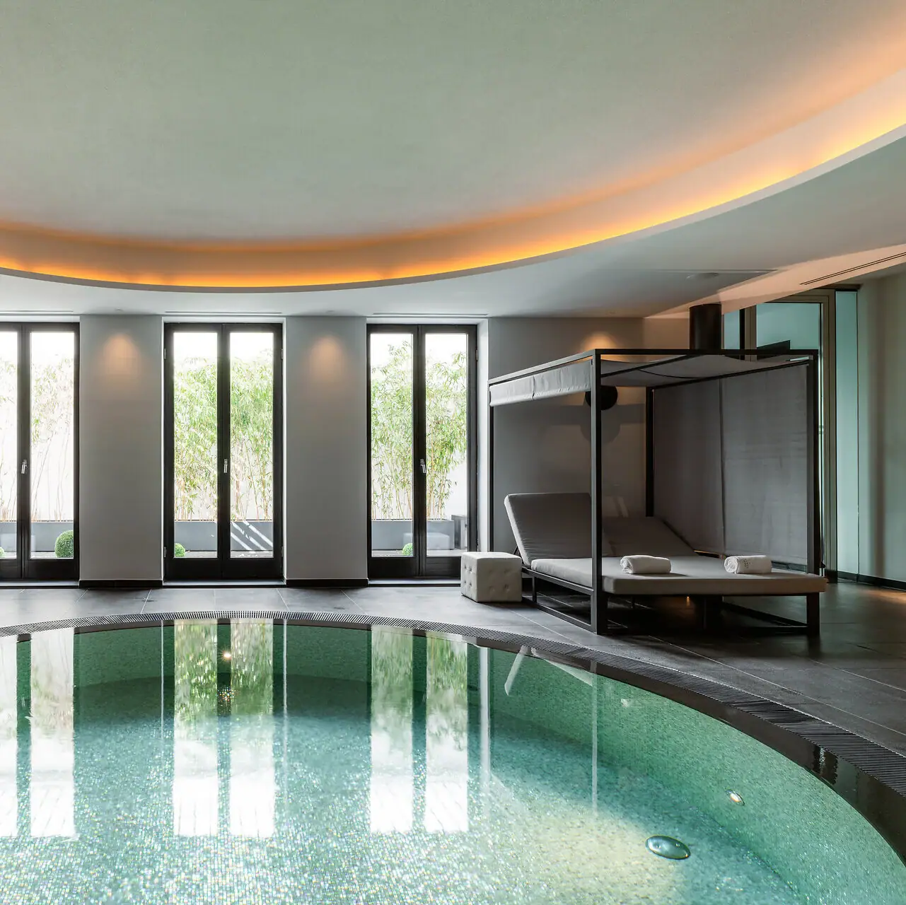 Ein Innenpool mit einem Bett und einem Baldachin darüber.