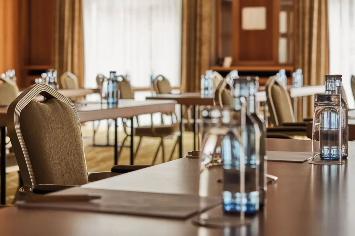 Ein Raum mit Stühlen und Tischen, eingerichtet mit Geschirr und Vasen.