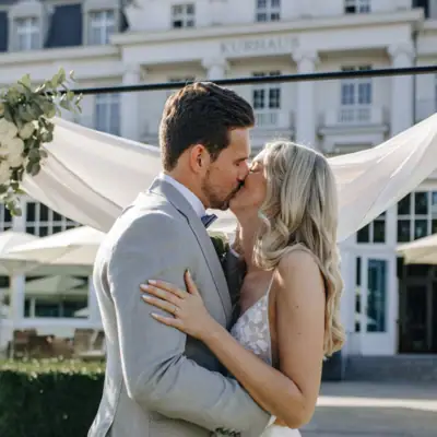 Hochzeit Travemünde Ein Mann und eine Frau küssen sich im Freien, die Frau trägt ein Hochzeitskleid.