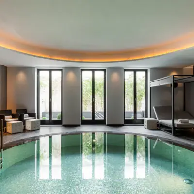 Ein Innenpool mit einem Day Bed und einem Baldachin.