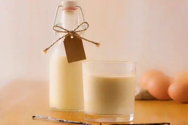 A-ROSA Eierlikör Eine Flasche und ein Glas Milch auf einem Tisch.