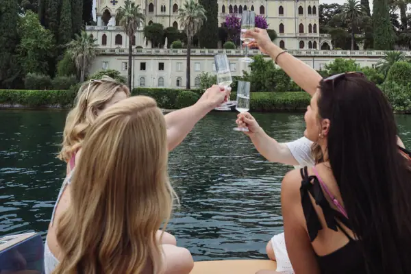 Bootstour Gardasee Eine Gruppe von Frauen hält Gläser vor einem See.