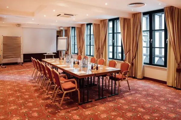 Tagungsraum Fischland Ein Zimmer mit einem Tisch und Stühlen.