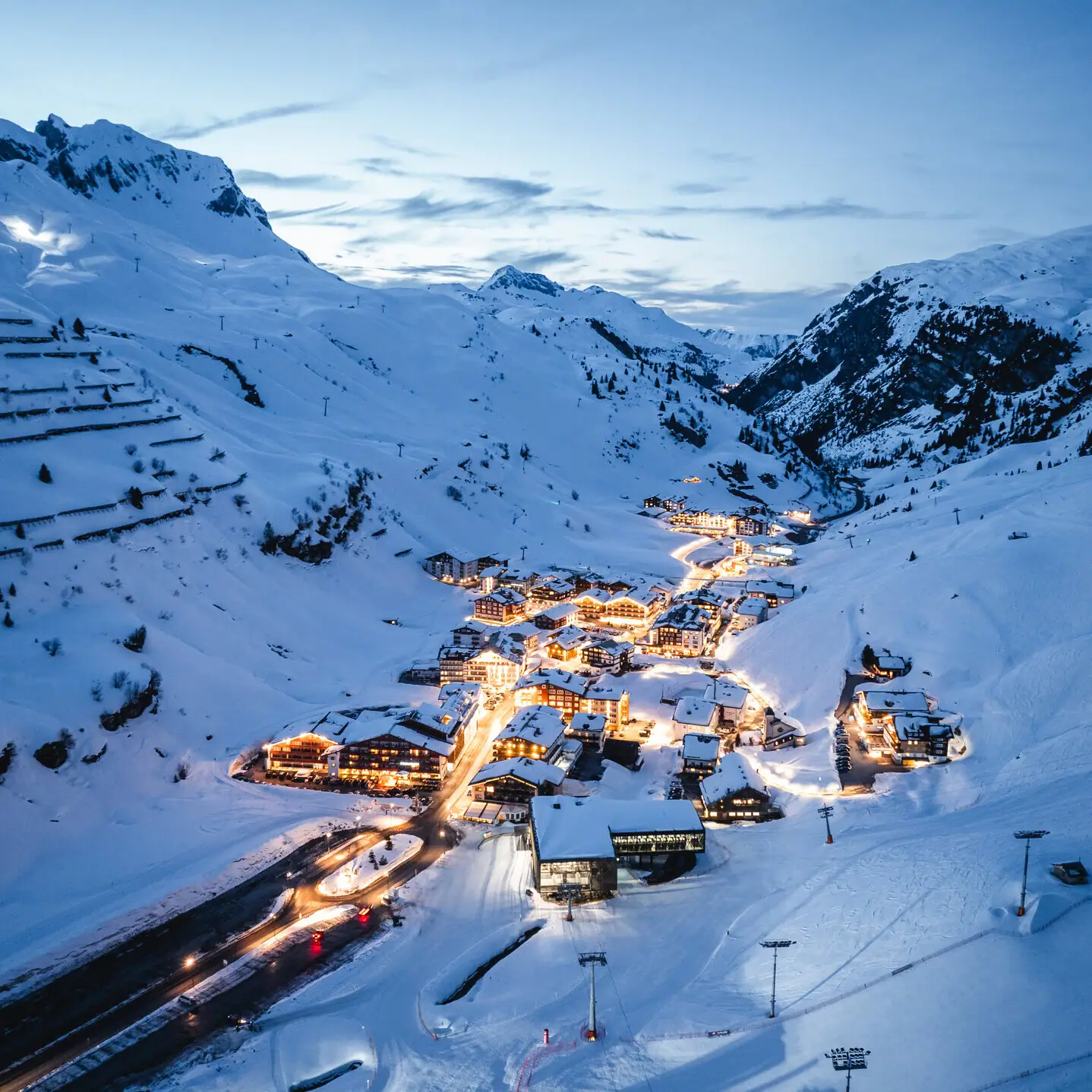 Bergstadt im Winter mit Schnee und Pisten.
