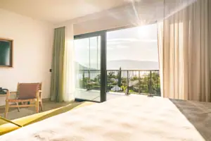 Zimmer Ein Zimmer mit einem Bett und einem Balkon mit Blick auf das Meer.