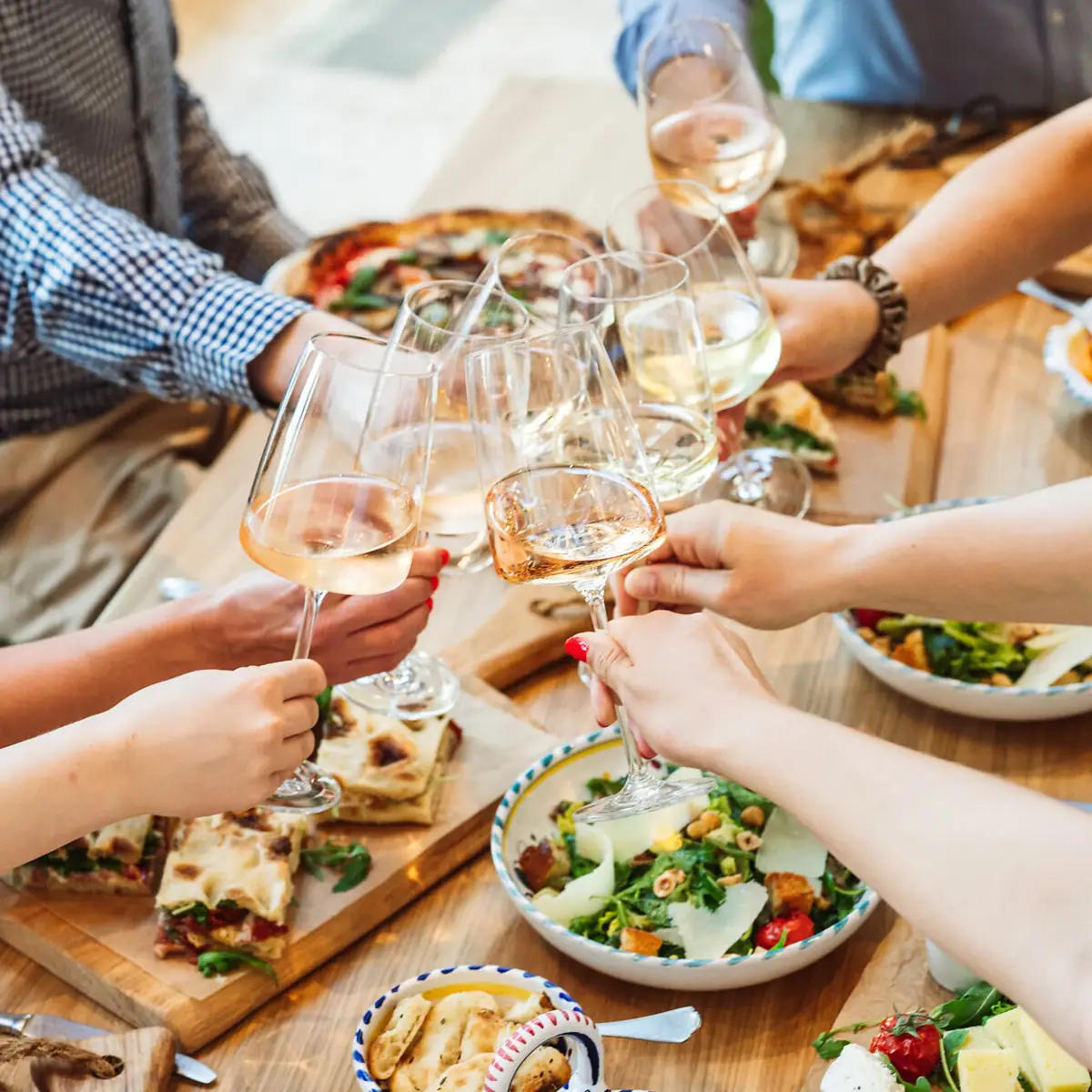 Eine Gruppe von Menschen hält Weingläser.