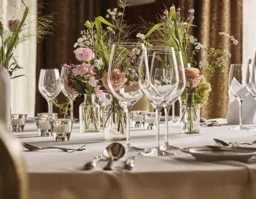 Ein Tisch gedeckt mit Blumen und Kerzen.