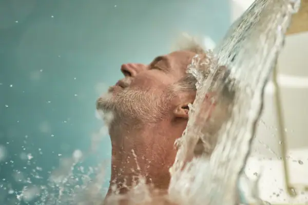 Ein Mann unter einem Wasserfall.