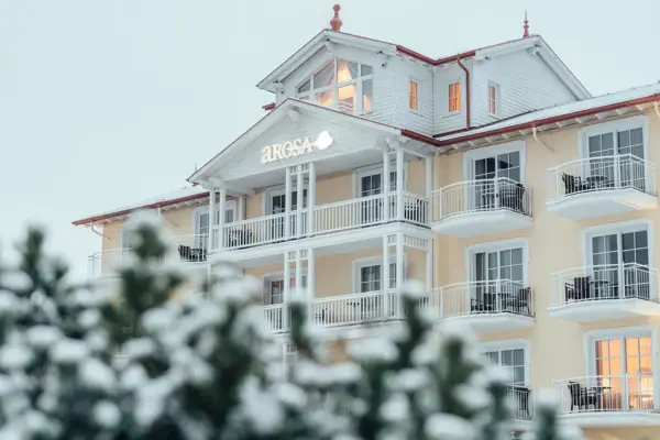 A-ROSA Ostseehotel Kühlungsborn Ein Gebäude mit Schnee auf dem Boden im Winter.