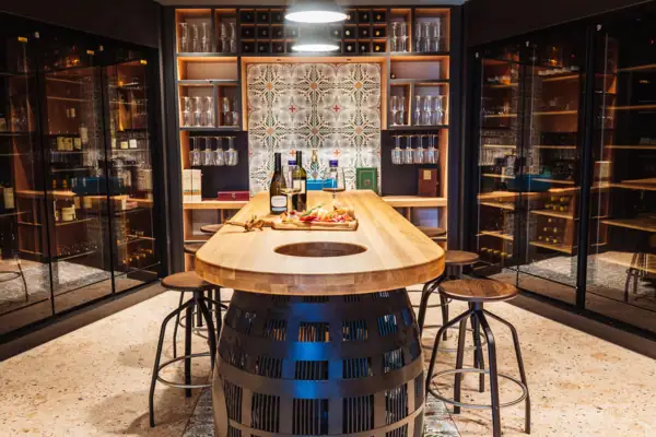 Enoteca im A-ROSA Gardasee Ein Tisch mit Weinflaschen und kleinen Snacks darauf.