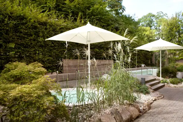 SPA-ROSA Travemünde Weiße Sonnenschirme neben einem Pool im Freien