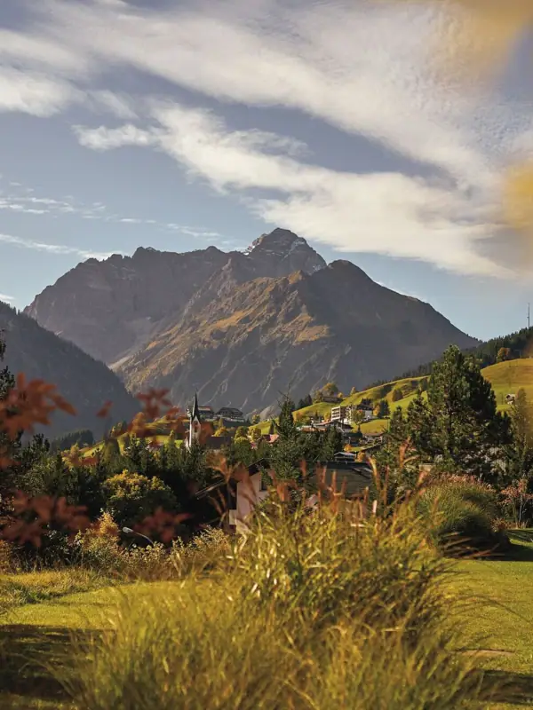Landschaft mit einem Berg im Hintergrund und Wolken am Himmel.