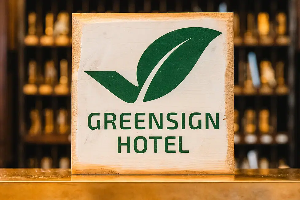 Schild auf einem Tresen mit einer Flasche daneben.