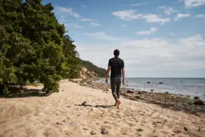Strand Ein Mann spaziert am Strand entlang.