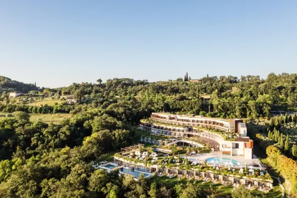 A-ROSA Hotel am Gardasee Ein Gebäude mit einem Pool, umgeben von Bäumen.