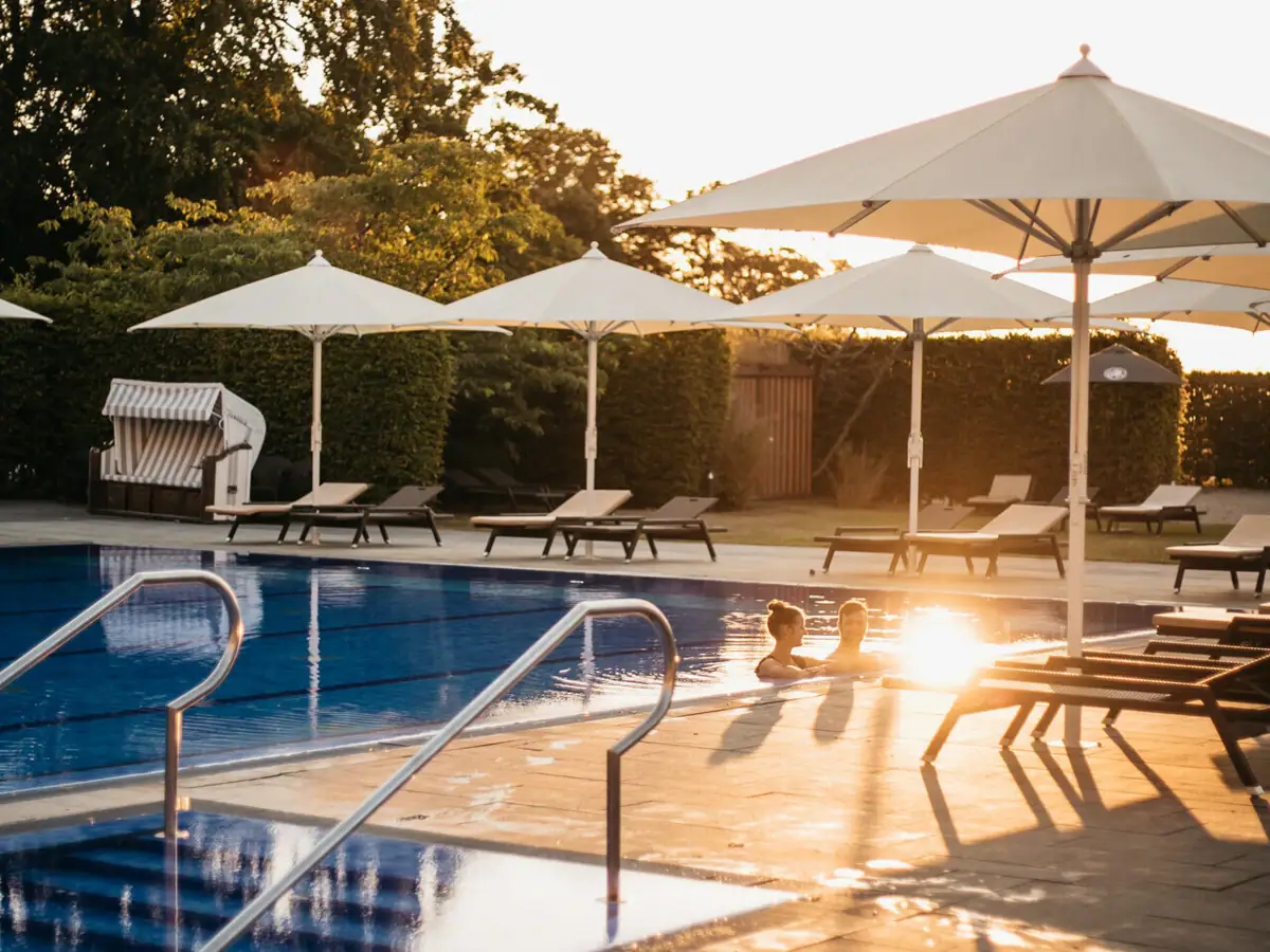 Außenpool Travemünde Ein Außenpool mit Sonnenschirmen und Liegestühlen.