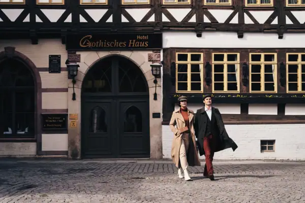 Gothisches Haus Ein Mann und eine Frau gehen vor einem Gebäude spazieren.