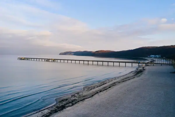 Strand Langer Steg am Strand mit Blick auf das Wasser und den Himmel.